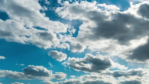 White Fluffy Clouds Slowly Float Through the Blue Daytime Sky Timelapse Stock Footage 194694344