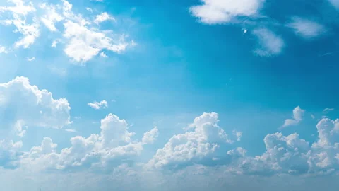 White Fluffy Clouds Slowly Float Through the Blue Daytime Sky Timelapse Stock Footage 209926140