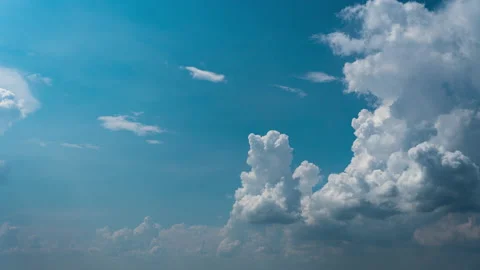 White Fluffy Clouds Slowly Float Through the Blue Daytime Sky Timelapse Stock Footage 210231156