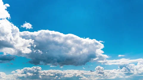 White Fluffy Clouds Slowly Float Through the Blue Daytime Sky Timelapse Stock Footage 214483539