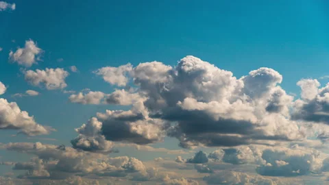 White Fluffy Clouds Slowly Float Through the Blue Daytime Sky Timelapse Video stock 215041240