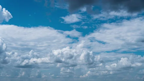 White Fluffy Clouds Slowly Float Through the Blue Daytime Sky Timelapse Video stock 215118576
