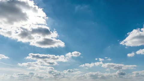 White Fluffy Clouds Slowly Float Through the Blue Daytime Sky Timelapse Stock Footage 218454362