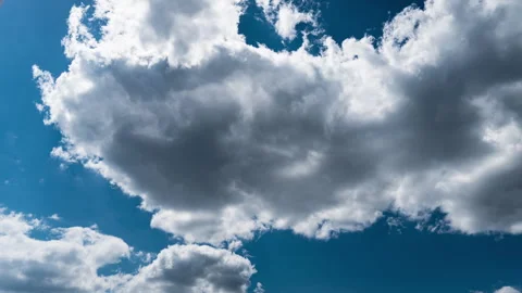 White Fluffy Clouds Slowly Float Through the Blue Daytime Sky Timelapse Stock Footage 243680107