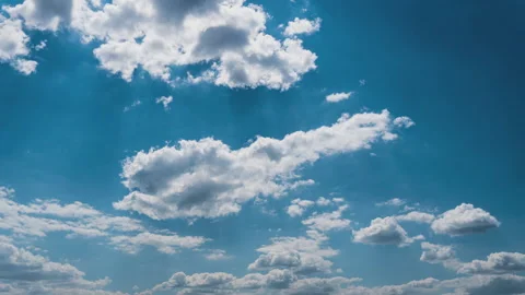 White Fluffy Clouds Slowly Float Through the Blue Daytime Sky Timelapse Stock Footage 244910129