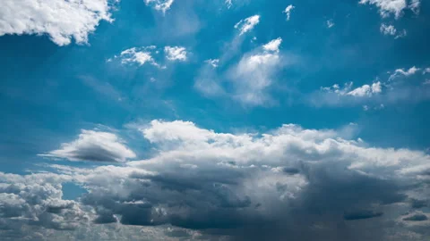 White Fluffy Clouds Slowly Float Through the Blue Daytime Sky Timelapse Stock Footage 248243758