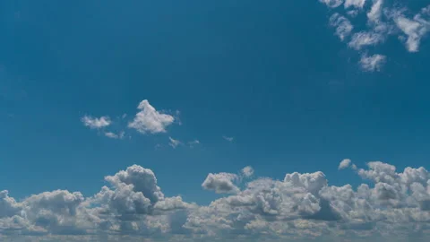 White Fluffy Clouds Slowly Float Through the Blue Daytime Sky Timelapse Stock Footage 250238609