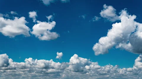 White Fluffy Clouds Slowly Float Through the Blue Daytime Sky Timelapse Stock Footage 250238621