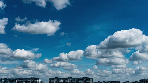 White Fluffy Clouds Slowly Float Through the Blue Daytime Sky Timelapse Stock Footage 252195905