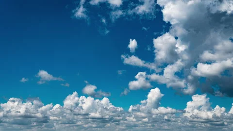White Fluffy Clouds Slowly Float Through the Blue Daytime Sky Timelapse Stock Footage 252199158