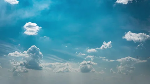White Fluffy Clouds Slowly Float Through the Blue Daytime Sky Timelapse Video stock 252887459
