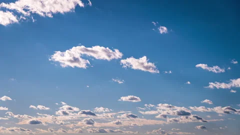 White Fluffy Clouds Slowly Float Through the Blue Daytime Sky Timelapse Stock Footage 255543500
