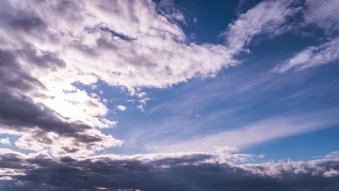 White Fluffy Clouds Slowly Float Through the Blue Daytime Sky Timelapse Video stock 260496506