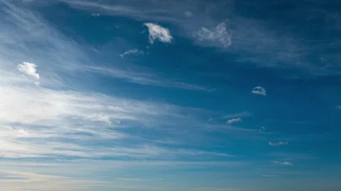 White Fluffy Clouds Slowly Float Through the Blue Daytime Sky Timelapse Stock Footage 260939483