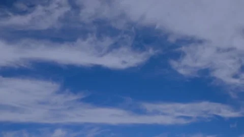 White fluffy clouds with wide stands float on the blue sky Stock Footage 137932620