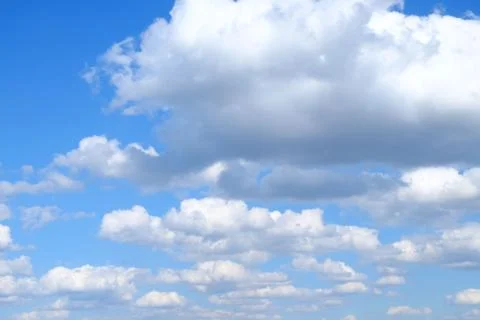 White fluffy cumulus clouds on a background of blue sky on a sunny day. Stock-Fotos