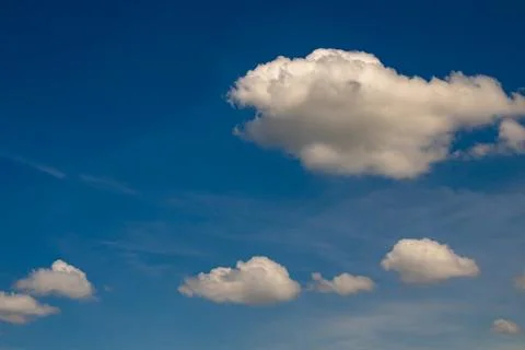White fluffy cumulus clouds floating across deep blue summer sky with seren.. 写真素材