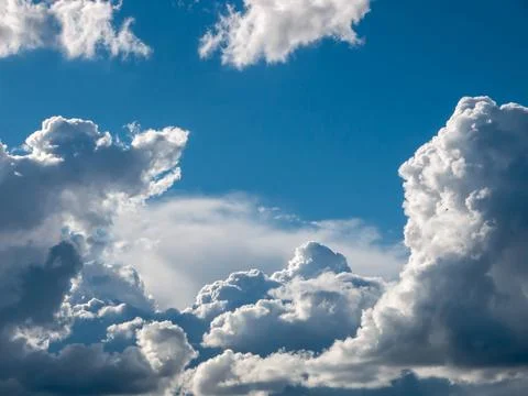 White fluffy epic clouds on blue sky Stock Photos