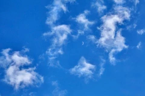 White fluffy soaring clouds on a blue sky background Stock Photos