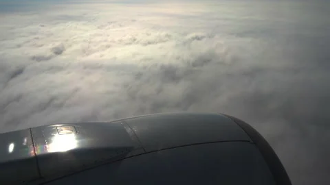 White fluffy soft clouds from airplane window in sunny sky and jet turbine. 库存影片 232961145