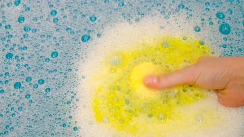 White foam in the bathBath bomb dissolves in blue water with foam. Bath products Stock Footage 232809924