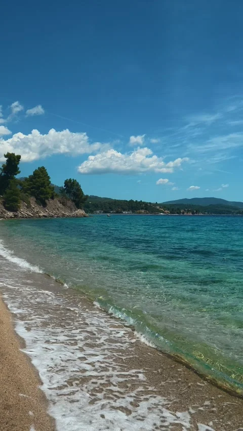 White foam dances gently where sea kisses shore. Lagomandra, Greece. Vertical Stock Footage 339628040