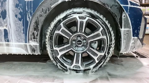 White foam from detergent drops down from blue car wheel Stock Footage 193964821