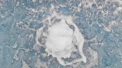 White foam explosion on surface of blue pool water Stock Footage 317345997