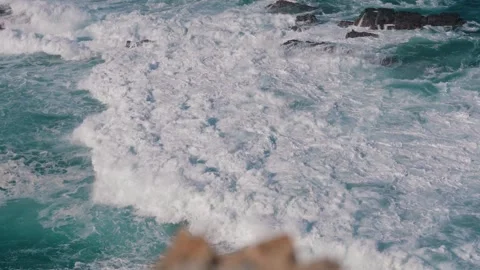 White foam of a large wave surging below the cliffs, Cabo Sardao, Portugal Stock Footage 346479853