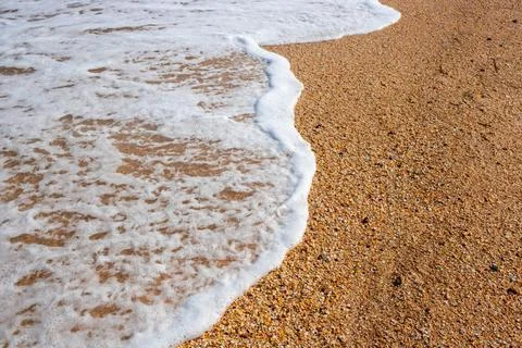 White foam wave on the background of a sandy beach White foam wave on the ... Stock-Fotos