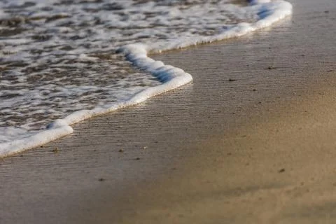 White foam from the waves at the sandy beach in egypt macro Foto stock