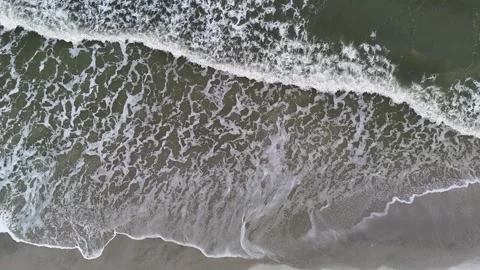 White foam waves in the sea lapping on the sandy beach. Wave after wave Stock Footage 286079649
