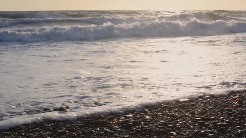 White foam waves in yellowish backlight crashing on the shore 스톡 동영상 234979074