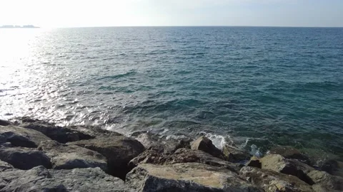 The white foams of the deep blue clear sea rising against the rocks. Stock Footage 219735328