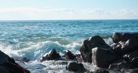 White foamy ocean waves breaking against rocks on beach in winter. Stock Footage 146055137