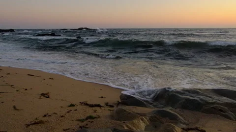 White foamy waves breaking on sandy beach at dusk Stock Footage 131896803