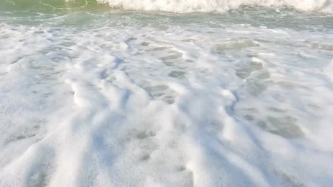 White foamy waves ocean splashing on seashore with Low angle Video stock 235583553