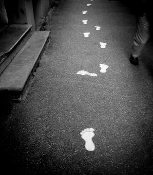 White footmark prints on a foot path showing direction and navigation Stock Photos