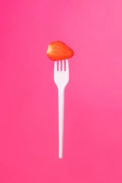 White fork with a slice of strawberries Stock Photos