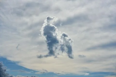 White forms and symbolic clouds on a blue sky. Stock Photos
