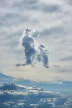 White forms and symbolic clouds on a blue sky. Stock Photos