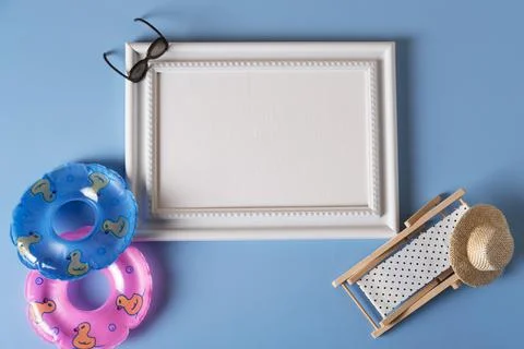 White frame with beach accessories, inflatable circles, sunglasses, and a cha Stock Photos