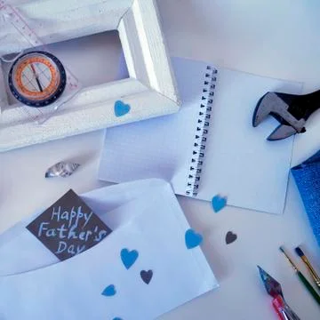 White frame, a compass a and a postcard to the day of the father Stock Photos