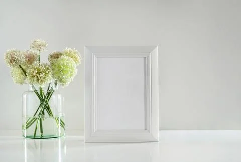 White frame on a table top and garlic flowers bouquet, front view Stock Photos