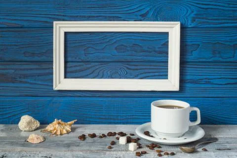 White frame, two coffee cups and a jug on a background of blue b 写真素材