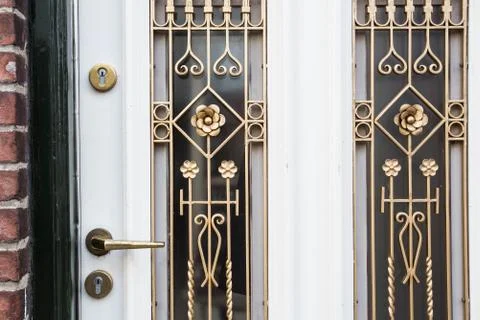 White front door with small square decorative windows close-up Stock Photos