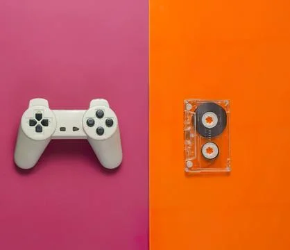 White game controller and cassette tape on colorful background Stock Photos