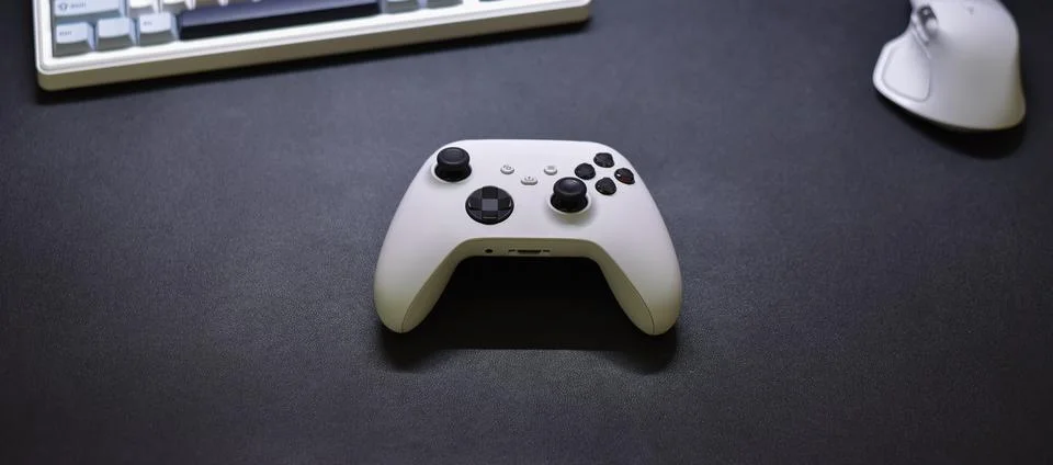 White game controller placed on dark textured surface, overhead shot Foto stock