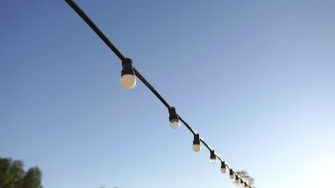White garlands with bulbs on a background of blue sky Stock Footage 117534353