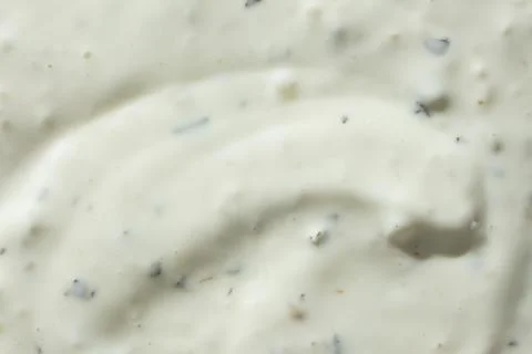 White garlic sauce background with flecks of spices Stock Photos